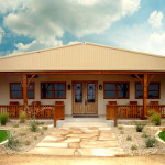 Residential steel building with porch and landscaping