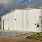 Steel workshop building with parking lot