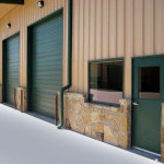 Green and tan steel automotive shop with stone accents