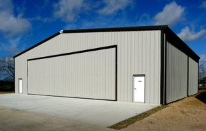 Photo of a grey steel airplane hangar with black trim.