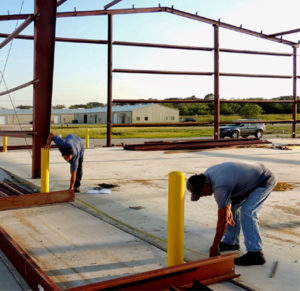 Photo of two men assembling a RHINO building.