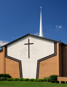 Photo of a steeple-topped steel church with brick trim.