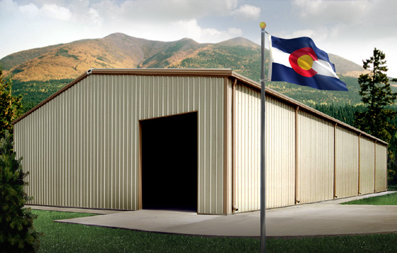 A Colorado state flag flies before a RHINO metal building against a Colorado mountain