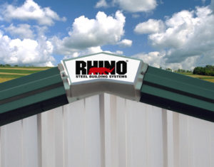 Image shows the RHINO logo on the roof peak of a steel building.