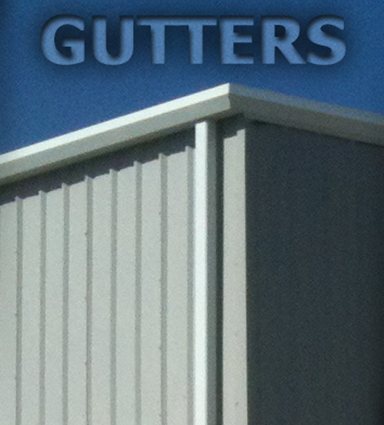 Close up of a white steel gutter system and downspout on the corner of a gray metal building