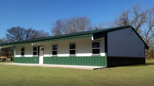 A white steel building with dark green trim creates a steel home