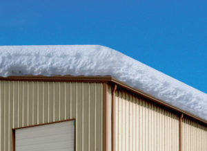 Snow piled high on a metal building roof/