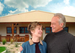 Photo of smiling senior couple before a RHINO steel-framed home.