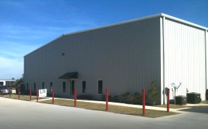 Photo of a large RHINO industrial building with light gray siding and white trim