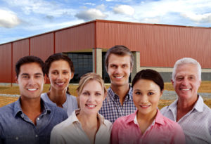 Happy workers stand before a prefabricated steel building.