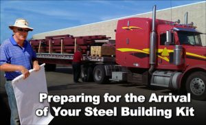 man with blueprint stands in front of 18-wheel truck delivering a steel building kit