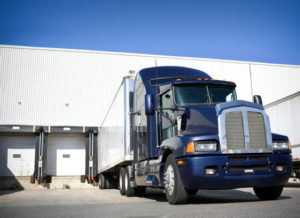 Eighteen wheeler truck backed up to the dock of as in steel warehouses and distribution centers.