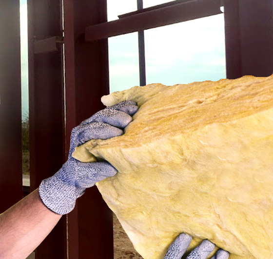 Hands installing insulation in a steel building