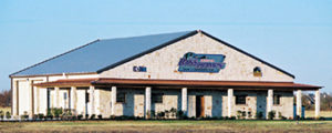 Photo of a RHINO commercial building with white stone and a blue metal roof.